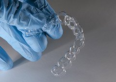 Gloved hand holding Clear Aligners clear aligner in Waverly