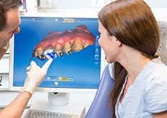 Dentist showing a patient impressions of their teeth before making C E R E C same day dental crown