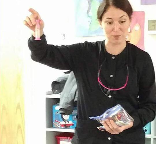 Dental team member showing dental product to kids