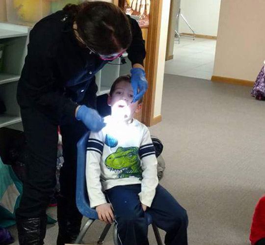 Dental team member giving boy a checkup