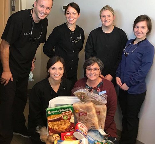 Dental team members with donated food items