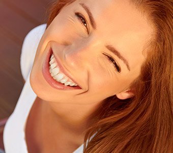 woman smiling up in sunlight