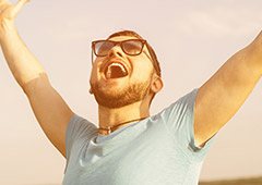 Man smiling with arms raised in celebration