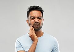 Man holding his cheek in pain