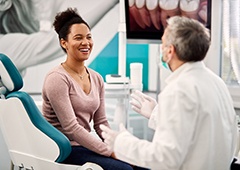 Woman smiling at her Waverly emergency dentist during consultation