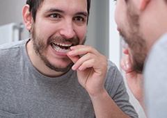 closeup of man putting on mouthguard 