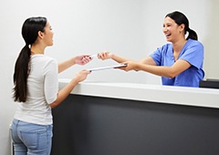 Patient in Waverly filling out forms for financing for dental implants