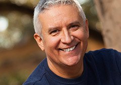 man in royal blue shirt smiling