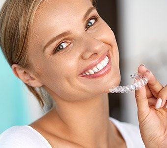 woman holding invisalign