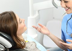 Dental assistant talking to patient in dental chair