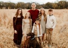 Doctor Vacek smiling outdoors with his family