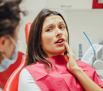 Woman holding her mouth in pain before root canal treatment in Waverly