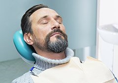 Man in turtleneck sweater relaxing in dental chair