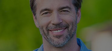 Man in blue collared shirt smiling