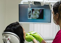 Dentist showing patient photos of their mouth with intraoral camera