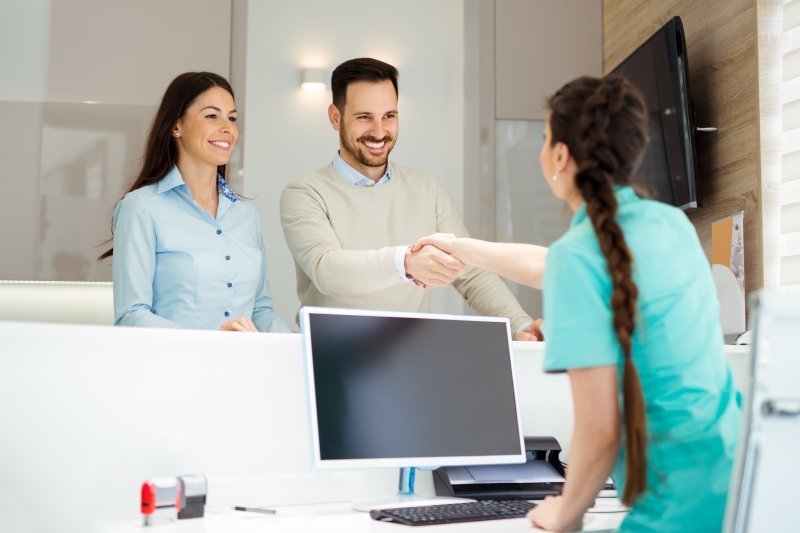 a couple shaking hands with the receptionist