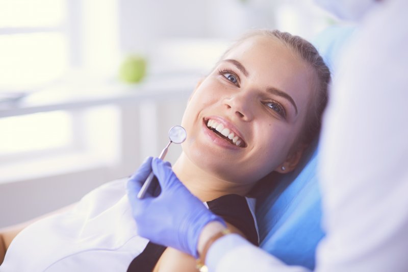a young woman smiling while preparing to undergo a regular dental checkup to ensure immune system protection in Waverly