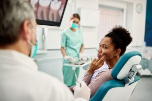Woman with toothache learning about root canal vs. extraction