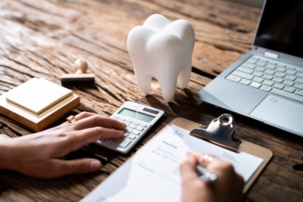 Patient calculating dental insurance information next to laptop