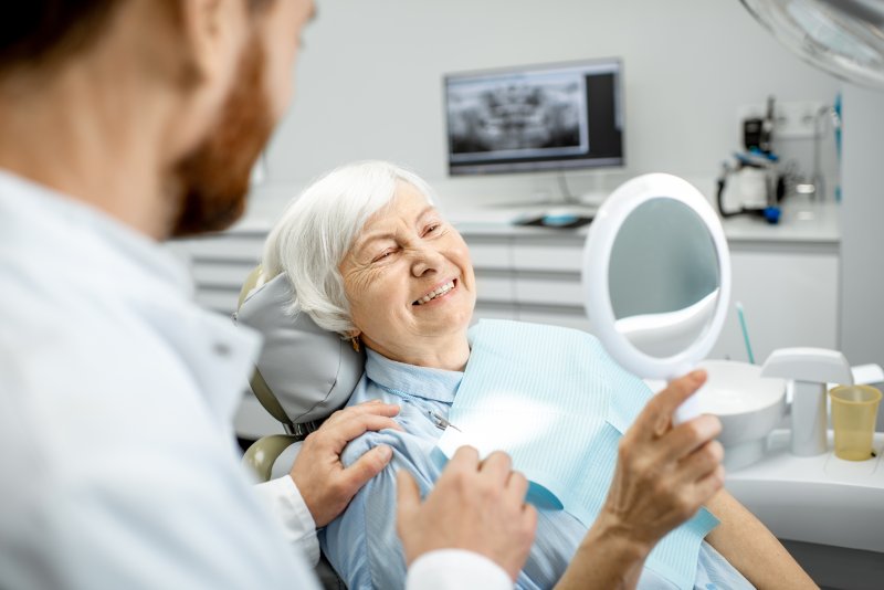 An elderly woman enjoying her new dental implants