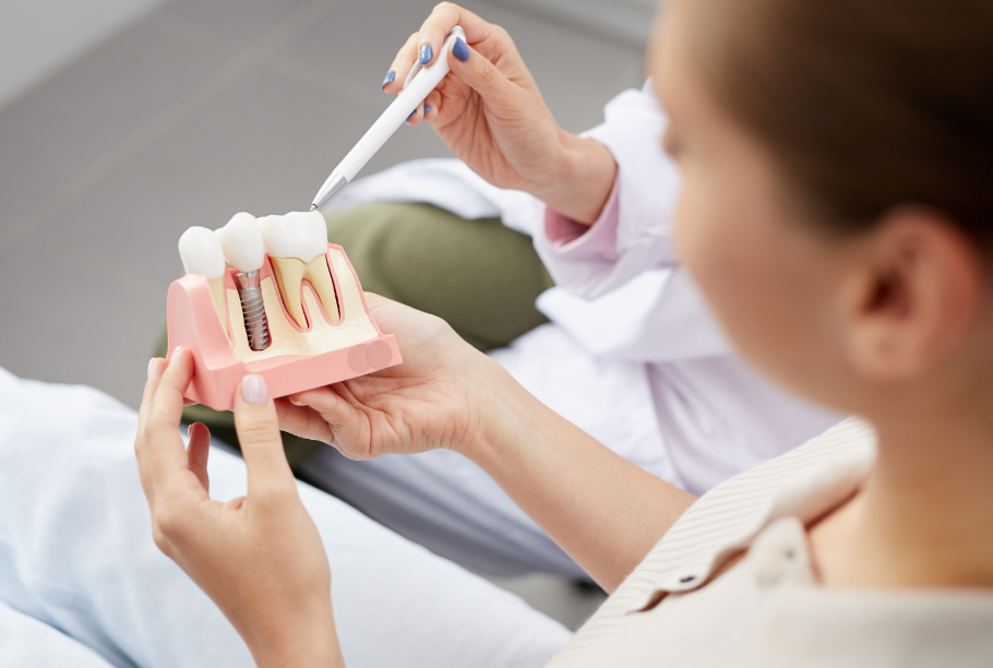 Dentist showing patient dental implant model